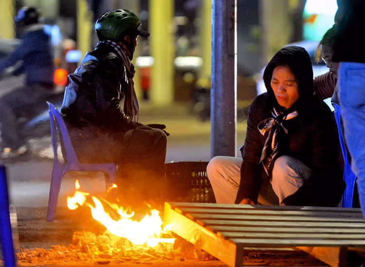 Người dân đốt lửa sưởi ấm khi nhiệt độ xuống thấp.