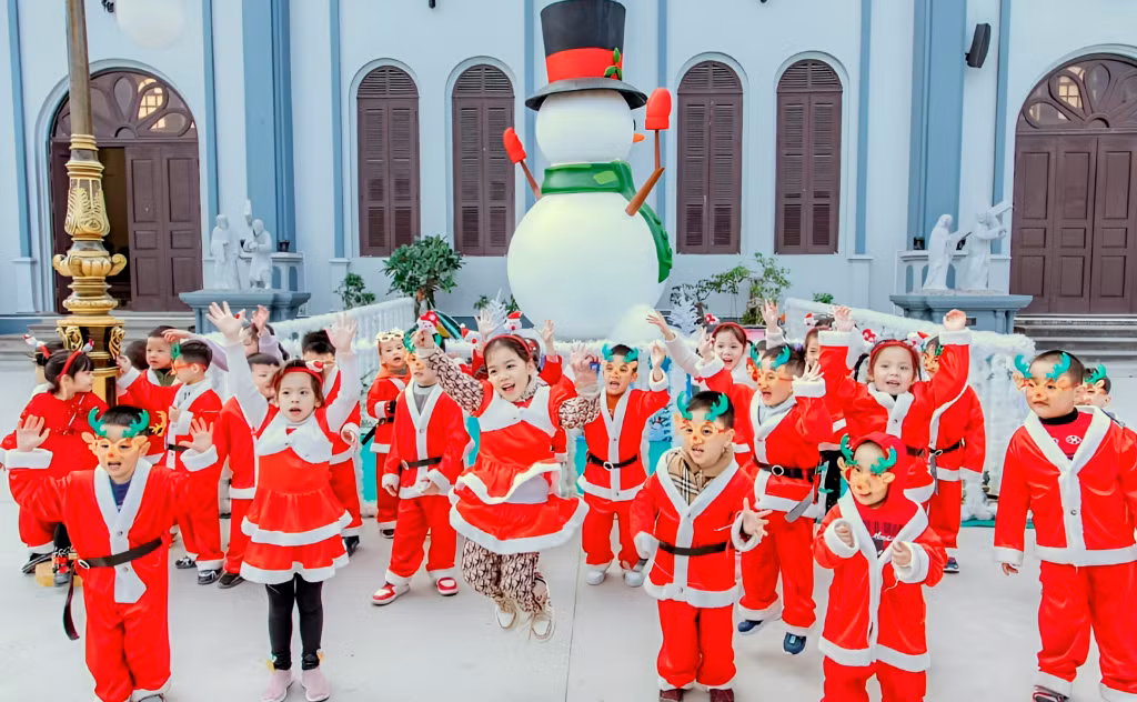 Các em nhỏ trong trang phục ông già Noel lưu lại những khoảnh khắc kỷ niệm bên tượng người tuyết khổng lồ tại Nhà thờ Hòn Gai.