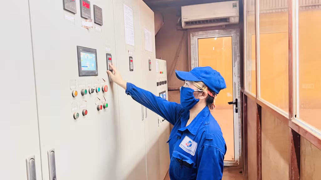 Chị Trần Thị Duyên điều hành hệ thống xả nhiệt nóng cho buồng nghiền.