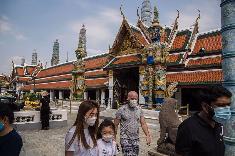 Du khách đeo khẩu trang khi đi thăm chùa tại Bangkok. Ảnh: Getty Images