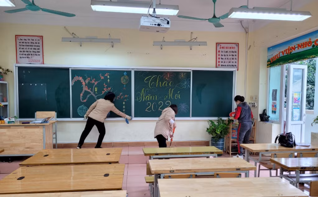 Các thầy cô giáo vừa vệ sinh, vừa trang trí bảng đen, phòng học để các em học sinh đến trường rộn ràng, tươi vui trong ngày "khai xuân".