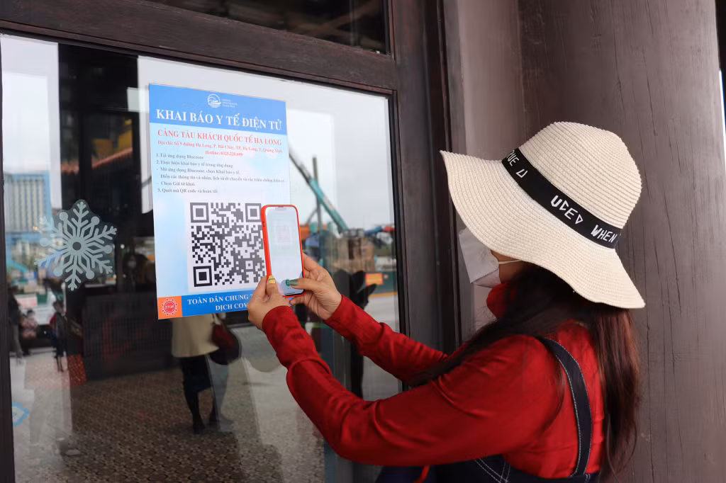 Du khách quét mã QR khai báo y tế tại Cảng tàu khách quốc tế Hạ Long. 