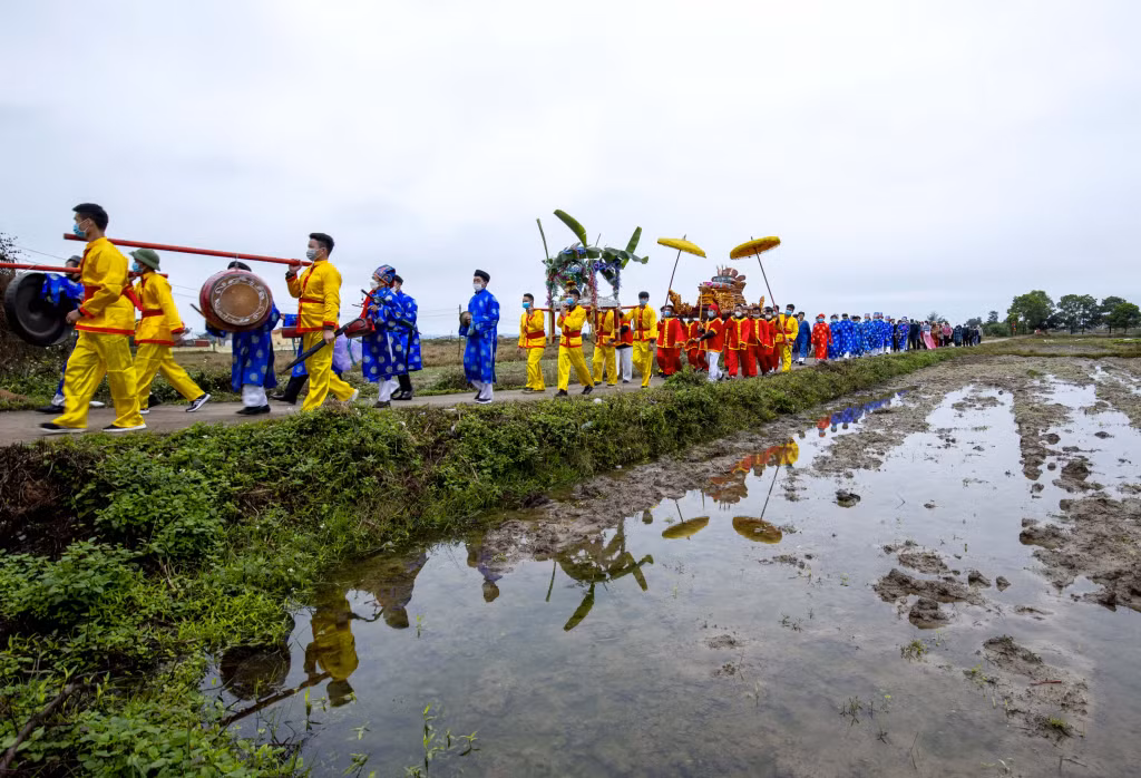 Đoàn rước thần đi qua cánh đồng đang chuẩn bị bước vào vụ chiêm xuân (2-2022). Ảnh: Dương Phượng Đại