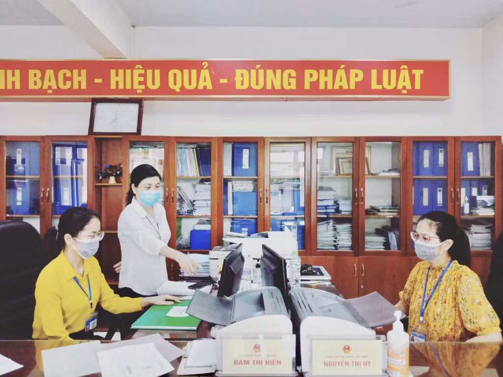 Bí thư Đảng ủy phường Cẩm Thạch (TP Cẩm Phả) Nguyễn Thị Tụ (áo trắng), hướng dẫn cán bộ làm việc tại bộ phận một cửa của phường.