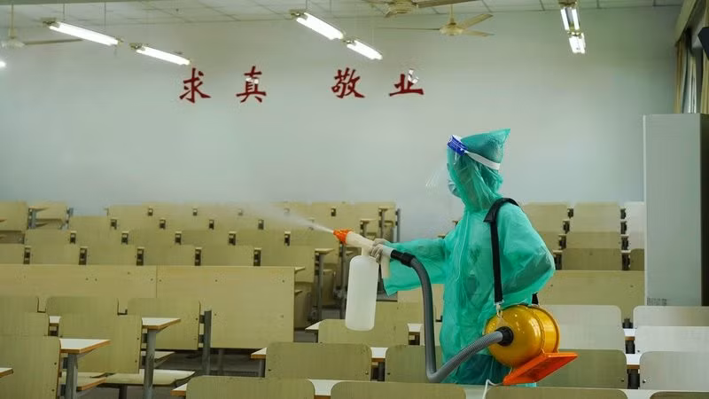 Nhân viên phun khử khuẩn lớp học tại một trường Đại học ở tỉnh Chiết Giang, chuẩn bị đón năm học mới. Ảnh: RTE
