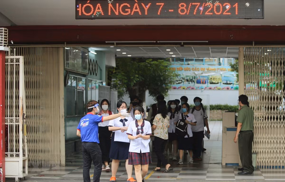 Thí sinh ra về sau khi hoàn thành bài thi Ngoại ngữ Kỳ thi tốt nghiệp THPT đợt 1 năm 2021 tại điểm thi trường trung học cơ sở Collete (quận 3). (Ảnh: Thành Chung/TTXVN)