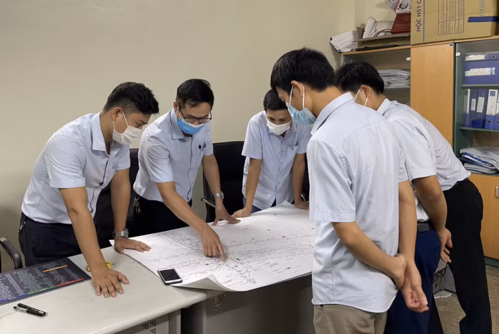 Lê Hoàng Việt (ngoài cùng, bên trái) trao đổi với lãnh đạo và đồng nghiệp Phòng Kỹ thuật về sáng kiến mới.