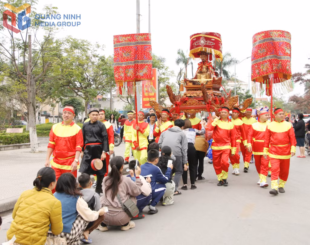 Người dân háo hức xếp hàng chui kiệu khi đoàn rước tượng Đức thánh Trần đi qua, với mong muốn cầu chúc bình an, may mắn, tạo nét văn hóa lễ hội độc đáo.