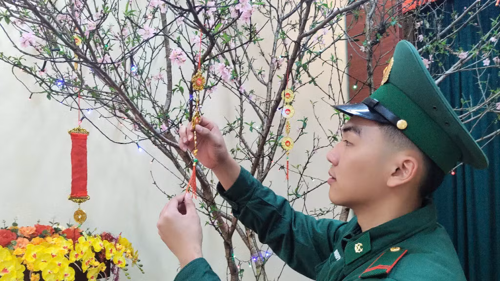 Chiến sĩ trẻ ở Đồn Biên phòng cửa khẩu Hoành Mô trang hoàng cây đào ngày Tết tại đơn vị.