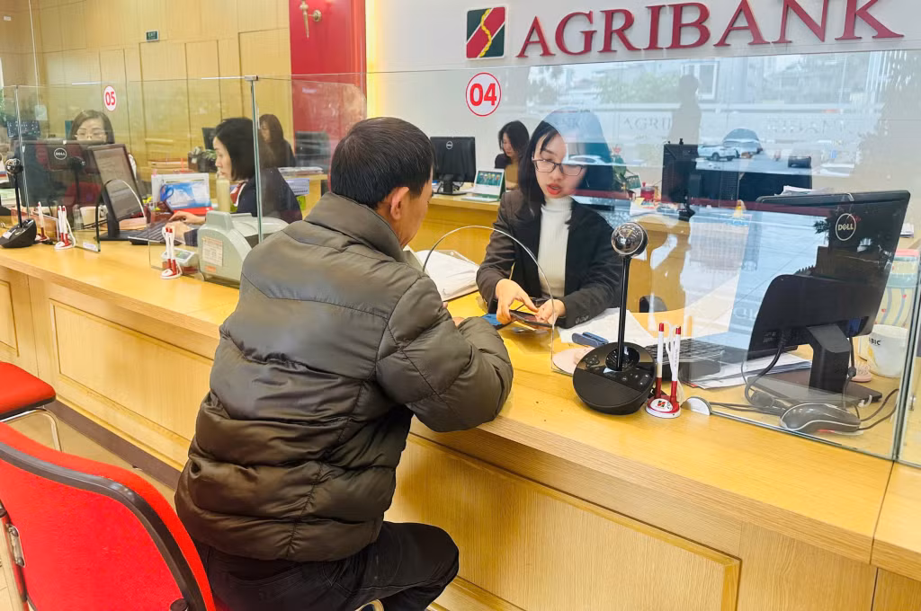 Nhân viên Agribank chi nhánh Quảng Ninh hỗ trợ khách hàng cập nhật thông tin sinh trắc học trên di động.
