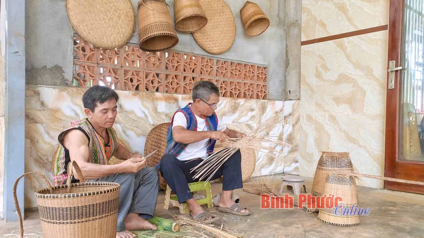 Anh Phạm Quốc Hưng đan lát cùng với già làng Điểu Dê