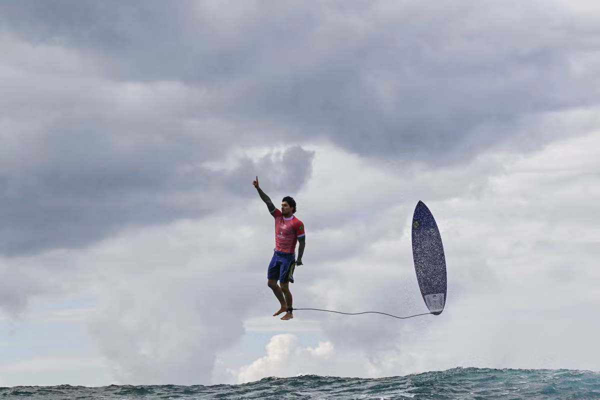 VĐV Brazil Gabriel Medina nhảy khỏi ván, giơ tay ăn mừng kết thúc phần thi vòng ba nội dung lướt sóng đơn nam Olympic Paris 2024 hồi tháng 7. Anh đạt điểm 9,9 trong phần thi, kỷ lục trong lịch sử Thế vận hội.