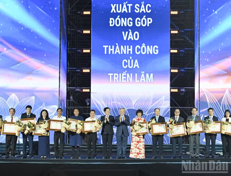 Phó Thủ tướng Thường trực Nguyễn Hòa Bình và Phó Thủ tướng Mai Văn Chính trao Bằng khen của Thủ tướng Chính phủ tặng các đơn vị, trong đó có Báo Nhân Dân, đã có thành tích xuất sắc trong công tác tổ chức và tham gia triển lãm. (Ảnh: TRẦN HẢI)