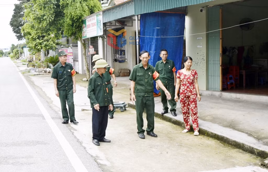 Các thành viên Tổ nhân dân tự quản ANTT do CCB làm nòng cốt xã Quảng Đức tuyên truyền đến người dân việc đảm bảo hành lang ATGT.
