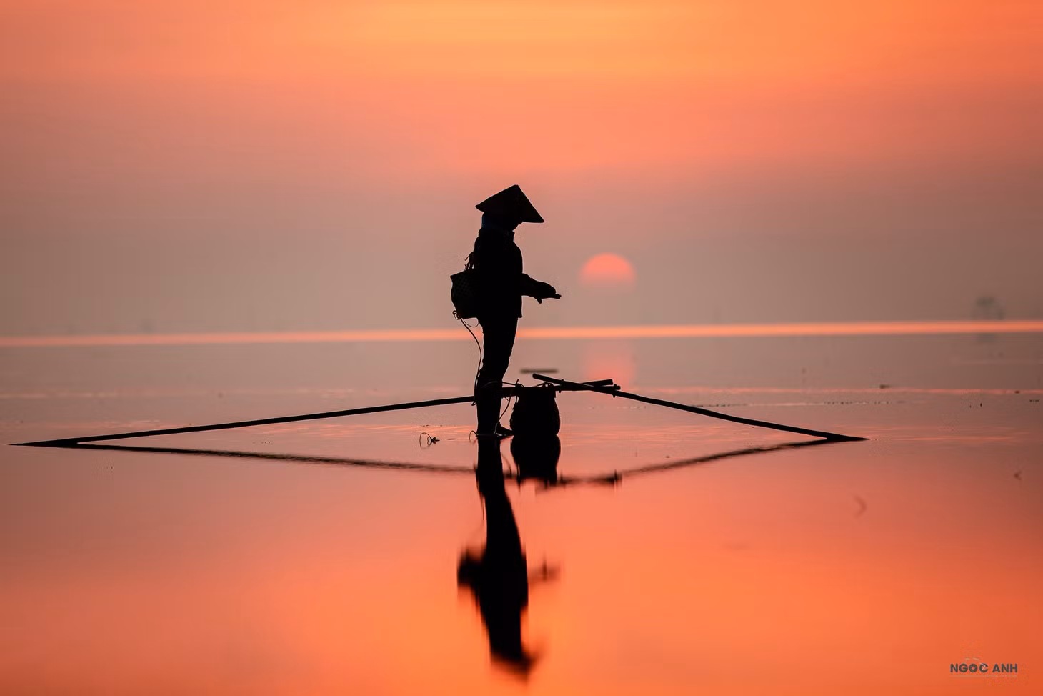 "Để có những bức ảnh này, tôi thường theo dõi thời tiết khá cẩn thận, đặc biệt phải có nắng, gió nhẹ và thuỷ triều thấp. Tôi chủ yếu đi tìm những khoảnh khắc có các cô chú đi lao động kiếm sống ngoài biển", vị nhiếp ảnh gia bộc bạch. Ảnh: Đoàn Ngọc Anh