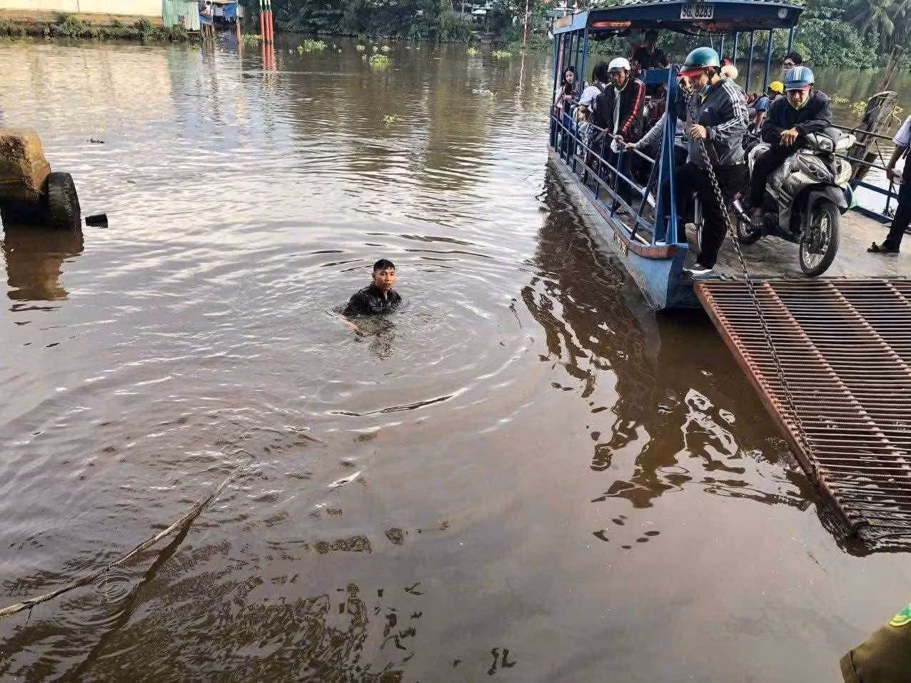 Thành viên của lực lượng an ninh cơ sở xã Bình Lợi (TPHCM) cứu em học sinh lao xuống sông. Ảnh: Đông Hoàng