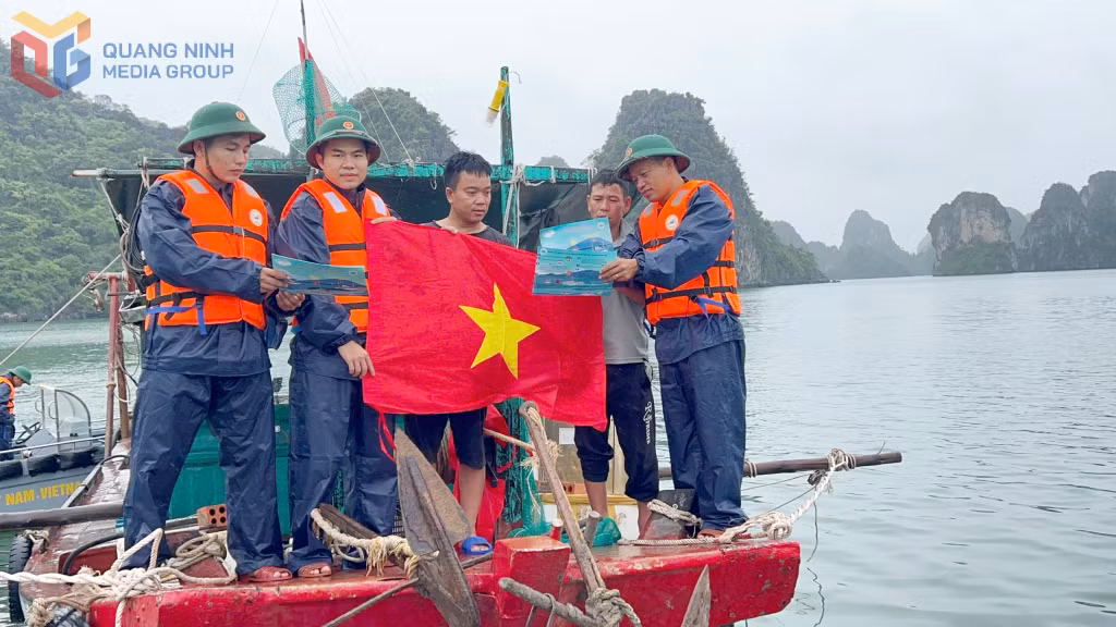 Cán bộ Hải đoàn Biên phòng 38 tặng cờ Tổ quốc cho ngư dân kết hợp tuyên truyền pháp luật cho ngư dân phường Liên Hòa, tỉnh Quảng Ninh.
