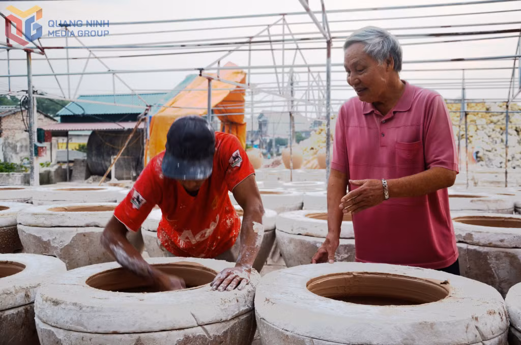 Nghệ nhân Ưu tú Lê Trọng Mỹ kèm cặp một thợ gốm trẻ tuổi.