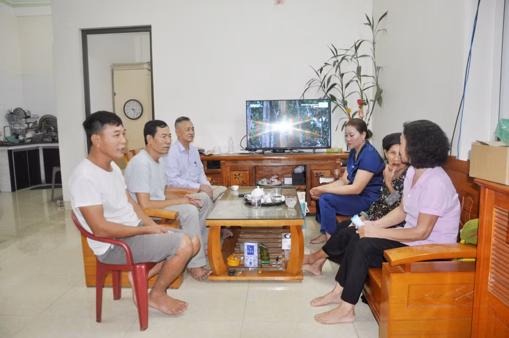 Ông Chính (trong cùng) và cán bộ khu phố trò chuyện với gia đình anh, chị Nguyễn Văn Giang, Đỗ Thị Thuỳ từng là hộ nghèo, về công việc làm ăn thời gian qua.