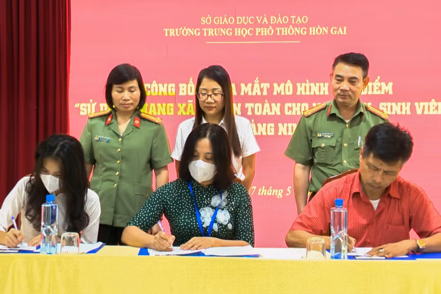 Đại diện nhà trường, phụ huynh và học sinh Trường THPT Hòn Gai (TP Hạ Long) ký cam kết triển khai mô hình “Sử dụng mạng xã hội an toàn cho học sinh, sinh viên", tháng 5/2022. Ảnh: Công an tỉnh