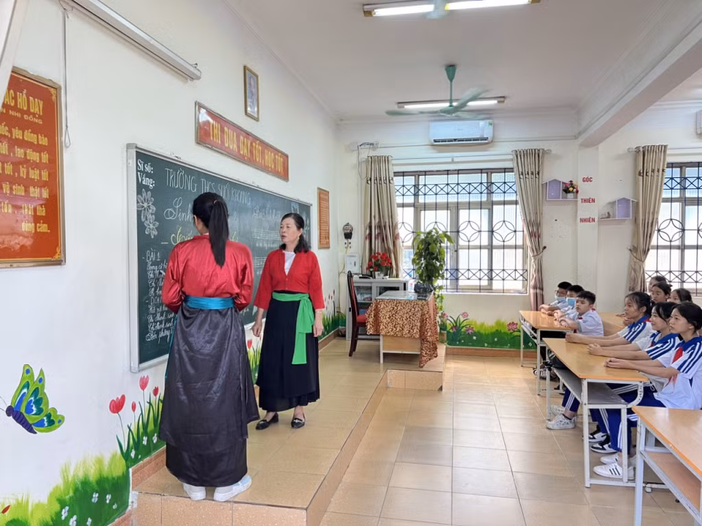 Bà Lê (bên phải) phối hợp dạy hát Soọng cô và tiếng Sán Dìu cho học sinh trong Chương trình ngoại khóa của Trường THCS Quang Hanh (TP Cẩm Phả)