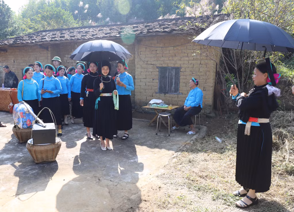 Người đón dâu cầm ô, chờ thầy làm lễ để chuẩn bị đón cô dâu về nhà chồng.