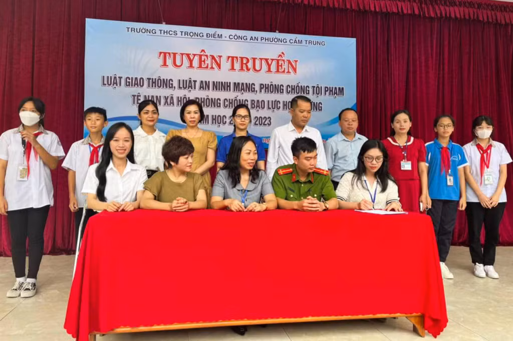 Đại diện học sinh, Hội cha mẹ học sinh Trường THCS Trọng Điểm, Công an phường Cẩm Trung (TP Cẩm Phả) ký cam kết chấp hành các quy định về ATGT trong năm học 2022-2023. Ảnh: Bảo Long (Trung tâm TT-VH Cẩm Phả)