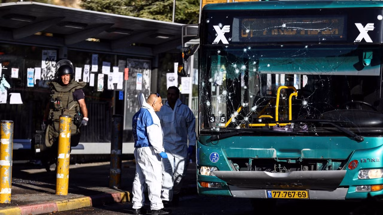 Chuyên gia xử lý bom và cảnh sát Israel làm việc bên cạnh chiếc xe buýt bị hư hại sau vụ nổ ở Jerusalem ngày 23/11/2022. Ảnh: Reuters
