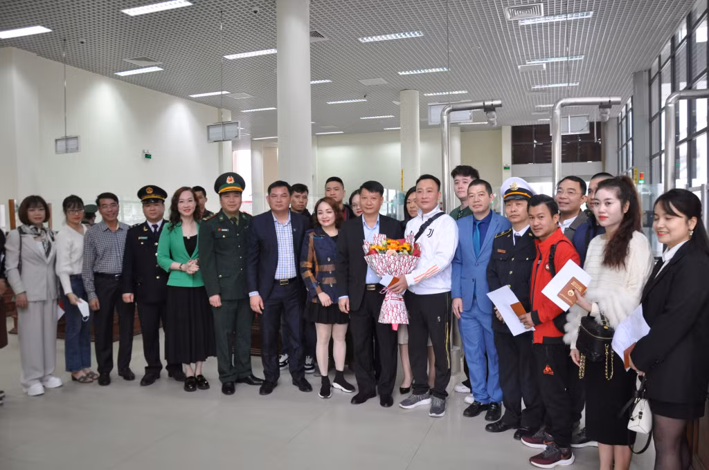 Lãnh đạo TP Móng Cái cùng đại diện các ngành khối cửa khẩu tặng hoa chúc mừng những người đầu tiên xuất, nhập cảnh qua Cửa khẩu Quốc tế Móng Cái sáng ngày 21/2