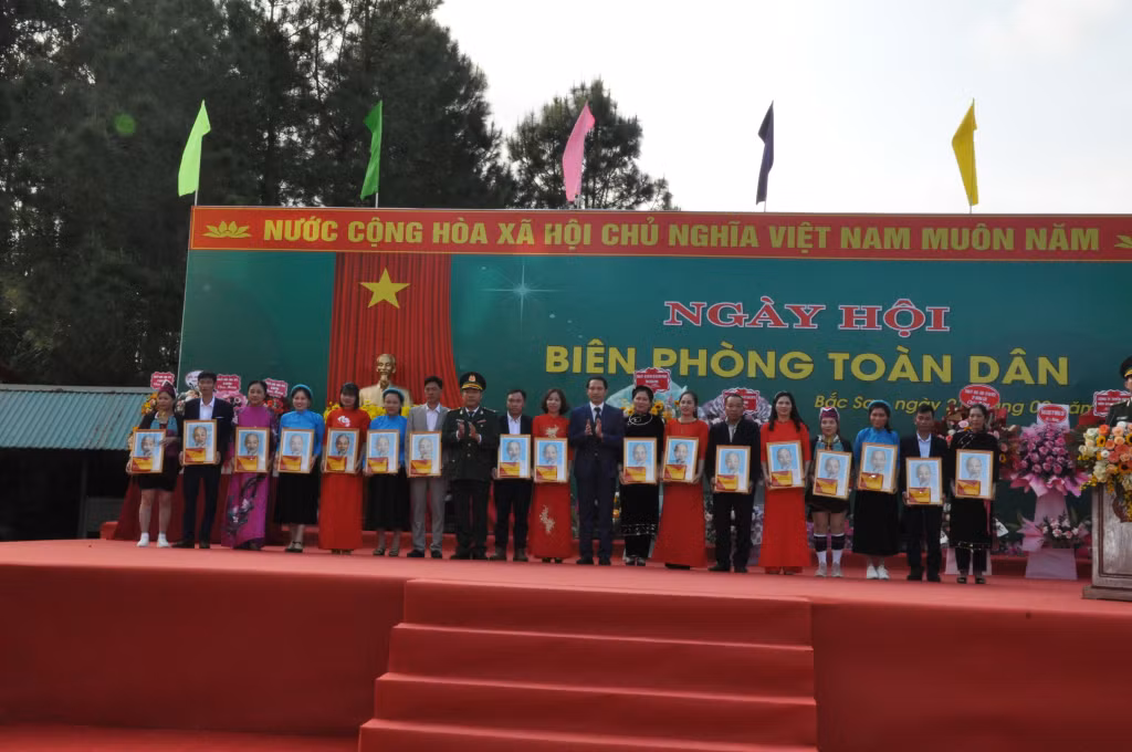 Đồn BP Bắc Sơn và UBND xã Bắc Sơn tặng cờ Tổ quốc và ảnh Bác Hồ cho người dân trên biên giới nhân Ngày hội Biên phòng