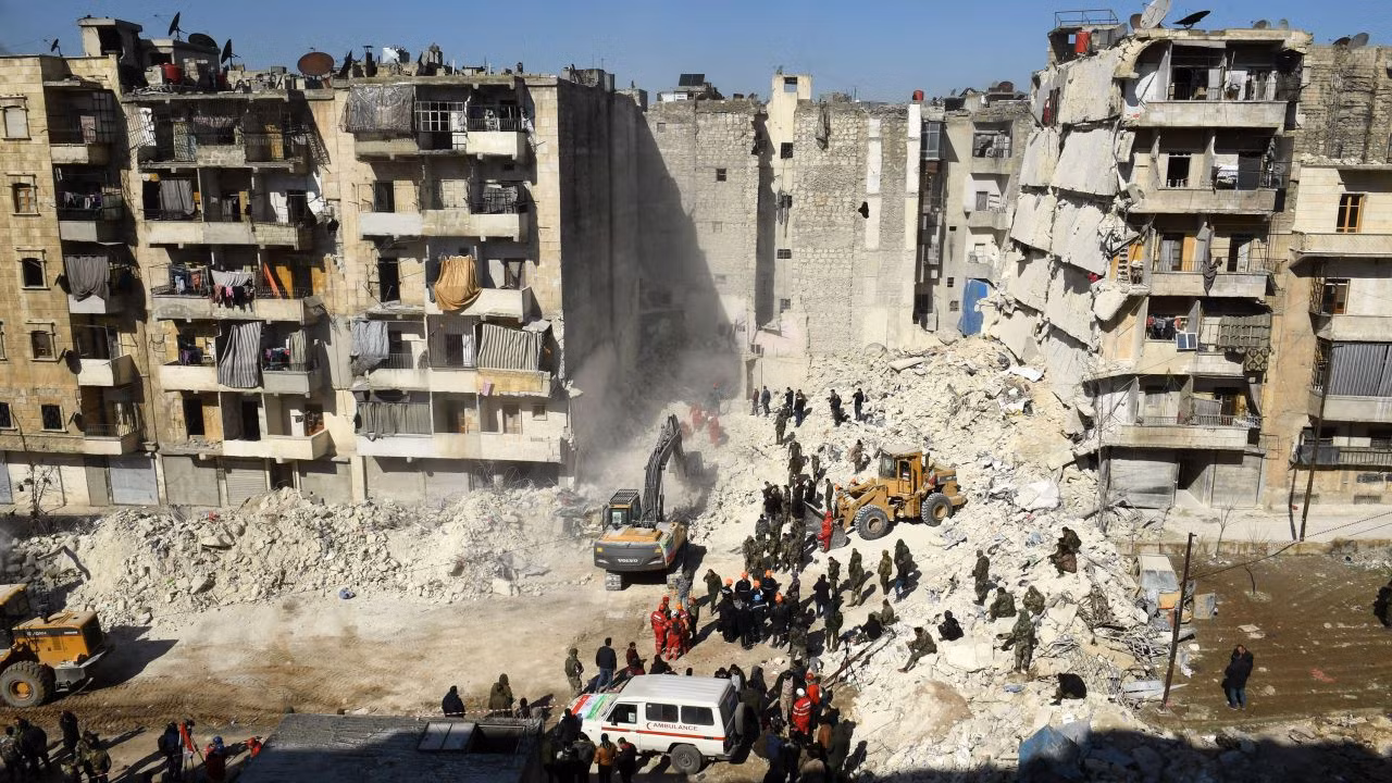 Binh sĩ Syria điều khiển phương tiện dọn dẹp đống đổ nát của tòa nhà bị sập ở Aleppo. Ảnh: AP