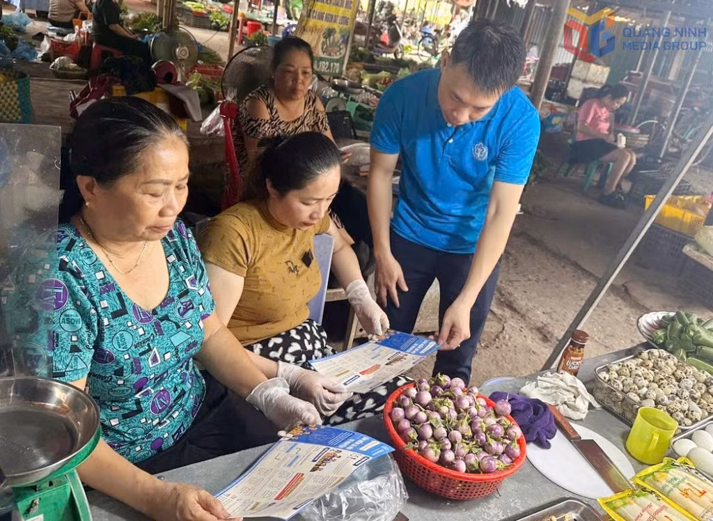 Cán bộ cơ sở BHXH Quảng Yên tuyên truyền các hộ tiểu thương tại chợ Rừng, phường Quảng Yên về chính sách BHXH, BHYT.