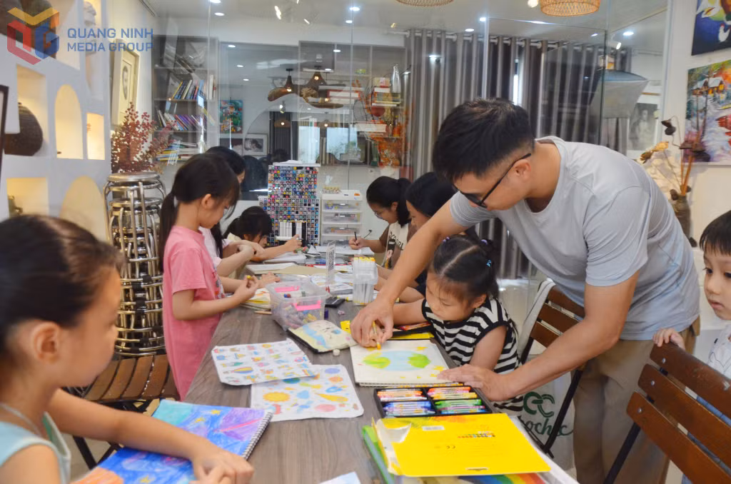 Hoạ sĩ Lưu Vũ Minh hướng dẫn các em nhỏ hoàn thành bài vẽ chủ đề Vũ trụ.