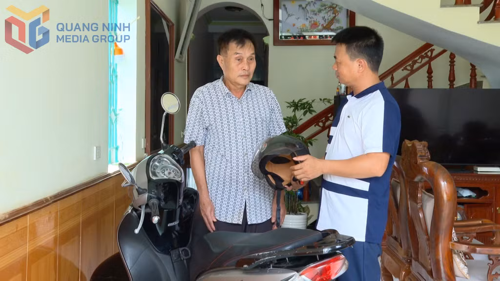 Anh Đinh Xuân Toàn, Bí thư Chi bộ, Trưởng thôn Đầm Buôn, xã Đầm Hà (bên phải) đang tuyên truyền Luật Trật tự, ATGT cho người dân.