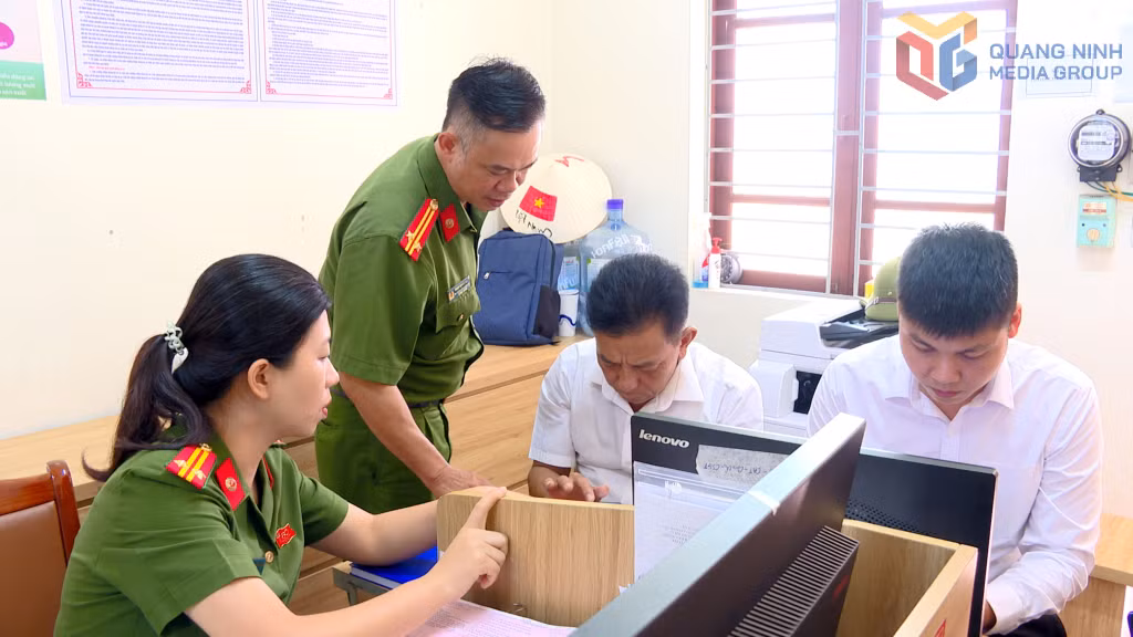 Cán bộ Tổ Cảnh sát giao thông trật tự (Công an phường Cẩm Phả) hướng dẫn, hỗ trợ công dân nộp hồ sơ đăng ký xe trên Cổng dịch vụ công. Ảnh: Hồng Việt