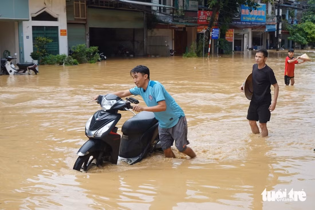 Người dân phường Linh Sơn mang xe máy đi gửi tránh lũ - Ảnh: VŨ TUẤN