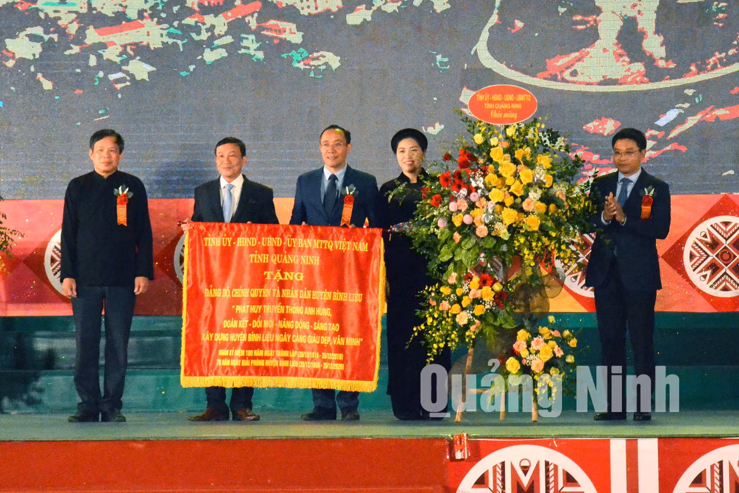 Chủ tịch UBND tỉnh Nguyễn Văn Thắng trao bức trướng với nội dung: “Phát huy truyền thống anh hùng, đoàn kết – đổi mới – năng động – sáng tạo, xây dựng huyện Bình Liêu ngày càng giàu đẹp, văn minh” cho huyện (12-2019). Ảnh: Mạnh Trường