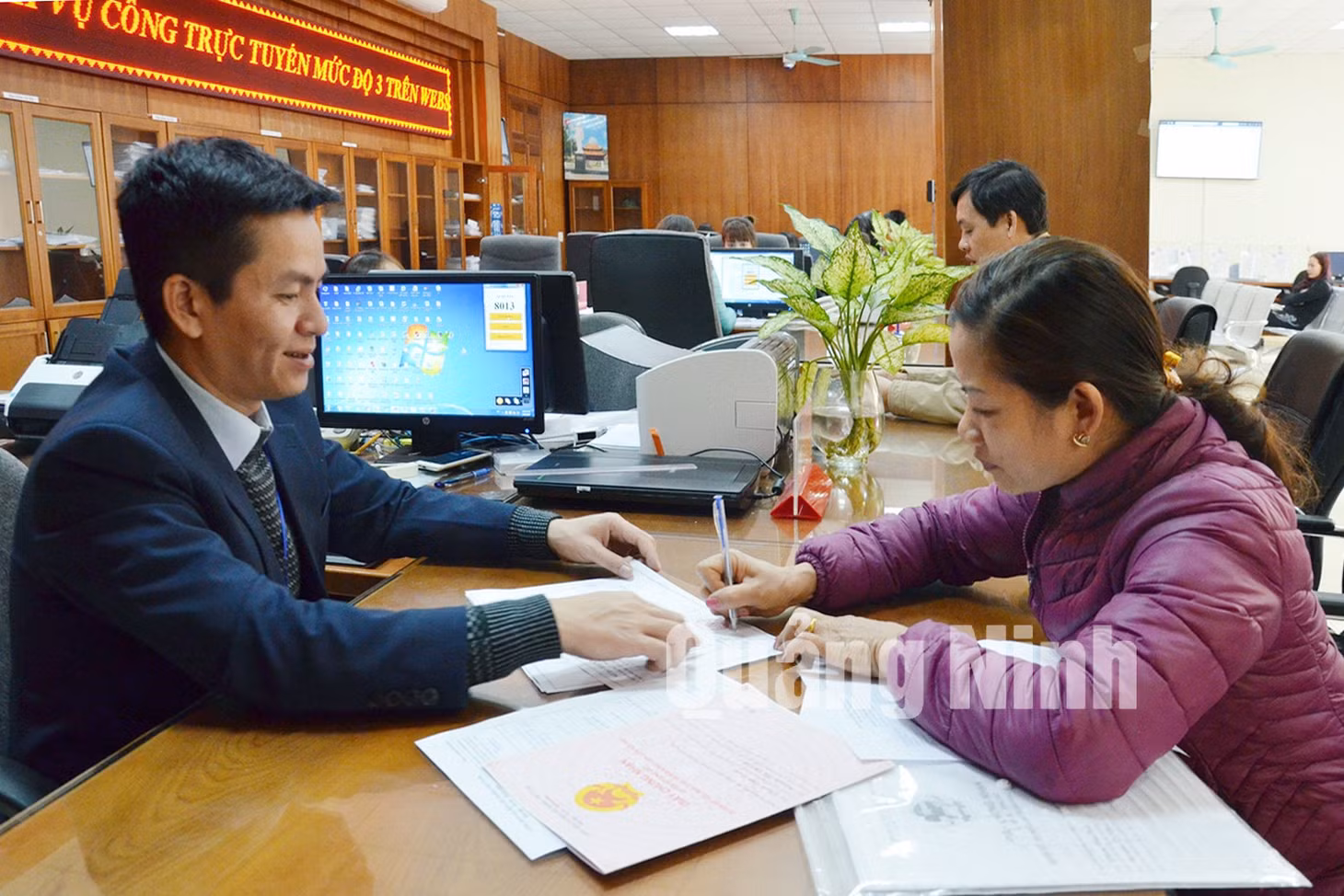 Cán bộ Trung tâm Hành chính công TP Cẩm Phả hướng dẫn công dân hoàn thiện hồ sơ thủ tục hành chính. Ảnh: Nguyễn Thanh