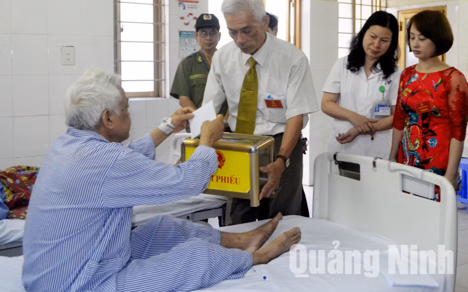 Các thành viên Tổ Bầu cử số 4, phường Bạch Đằng (TP Hạ Long) đưa hòm phiếu lưu động tới Bệnh viện Đa khoa tỉnh để cử tri thực hiện quyền bầu cử tại phòng bệnh. Ảnh: Hoàng Quý