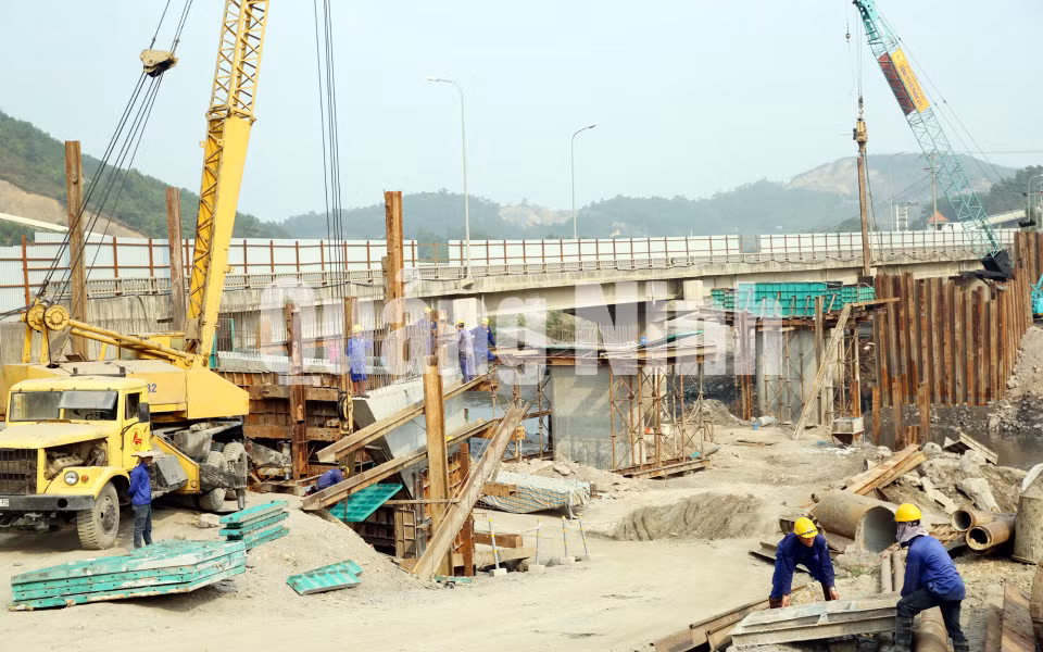 Thi công cấp phối đá dặm đoạn đường tránh TP Cẩm Phả và phần móng, trụ của cầu Mông Dương (4-2016). Ảnh: Đỗ Phương