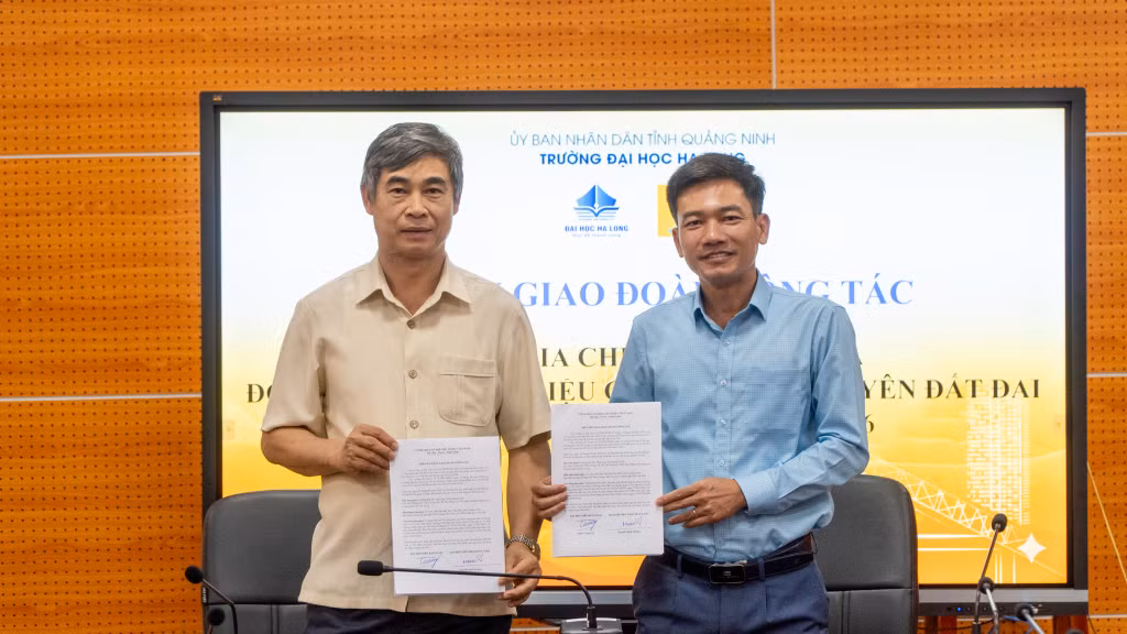 Tiến sĩ Trần Trung Vỹ, Bí thư Đảng ủy Trường Đại học Hạ Long và đồng chí Nguyễn Sinh Lượng, Phó Chủ tịch UBND đặc khu Vân Đồn, kí kết văn bản bàn giao đoàn công tác của Trường Đại học Hạ Long tham gia Chiến dịch số hóa cơ sở dữ liệu đất đai tại Đặc khu Vân Đồn năm 2026.