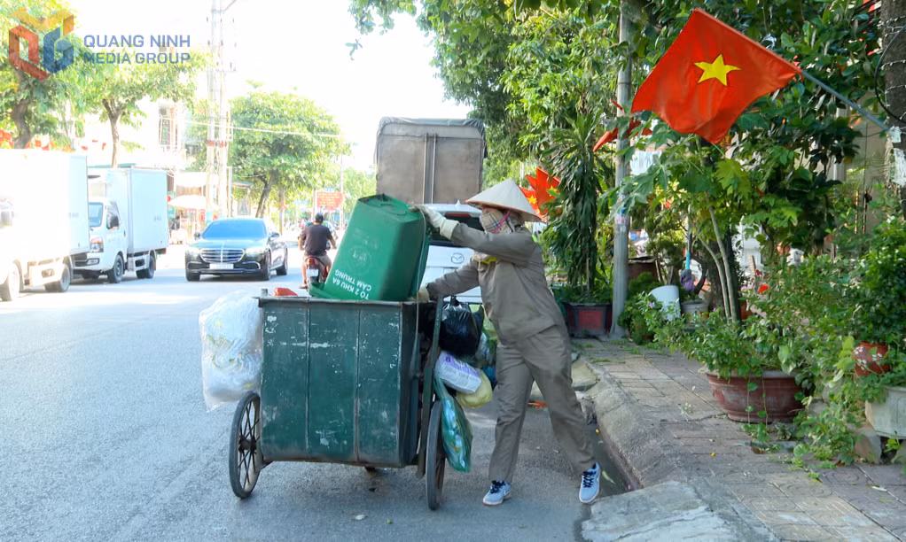 Công nhân Công ty CP Môi trường đô thị Cẩm Phả thu gom rác thải sinh hoạt trên địa bàn phường Cẩm Phả.