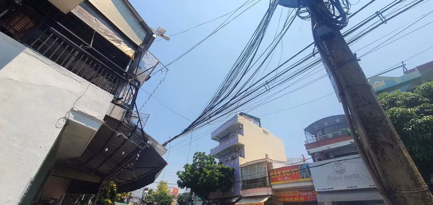 Nạn nhân rơi trúng dây điện trước tòa nhà. Ảnh: Phương Linh