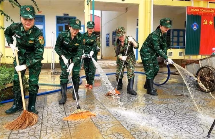 Hội phụ nữ Bộ đội Biên phòng Quảng Bình tích cực tham gia hỗ trợ dọn dẹp vệ sinh tại trường Mầm non và trường THCS Phong Thủy, huyện Lệ Thủy. Ảnh: TTXVN phát