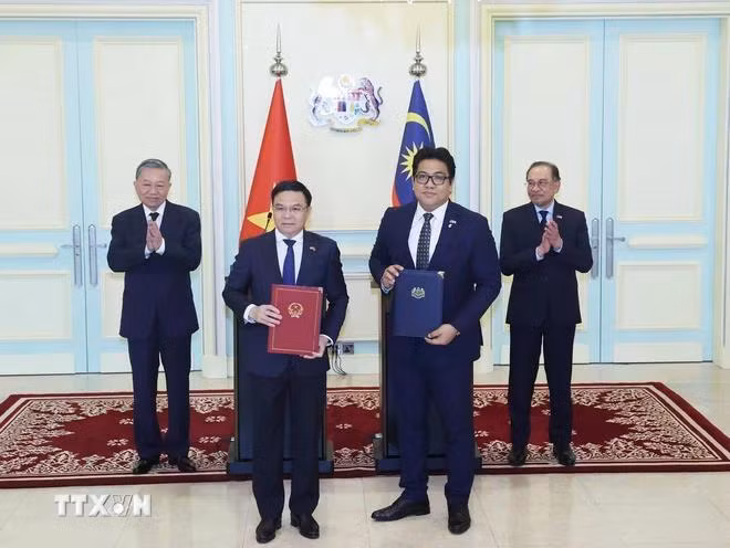 Tổng Bí thư Tô Lâm và Thủ tướng Malaysia Anwar Ibrahim chứng kiến trao đổi văn kiện hợp tác giữa hai nước. (Ảnh: Thống Nhất/TTXVN)