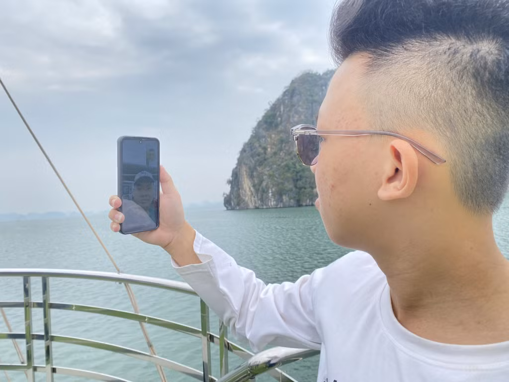 Du khách tham quan Vịnh Hạ Long facetime cho người thân ở khu vực có sóng điện thoại.