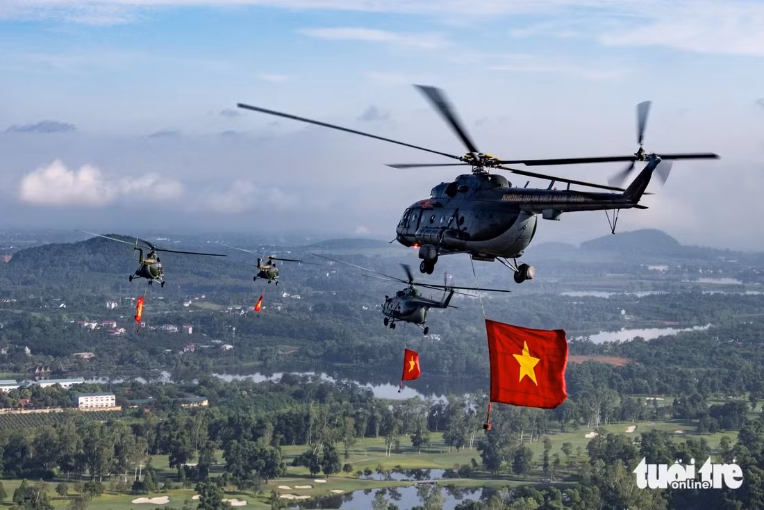 4 chiếc trực thăng với cờ Đảng, cờ Tổ quốc bay tại khu vực Hòa Lạc. Ảnh: ĐÌNH QUÝ