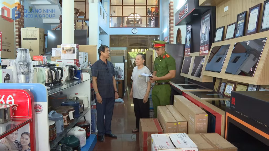 Ông Nguyễn Quang Ngợi, Bí thư Chi bộ, Trưởng khu 8, phường Uông Bí (bên trái) đang tuyên truyền Luật Trật tự, ATGT cho người dân.