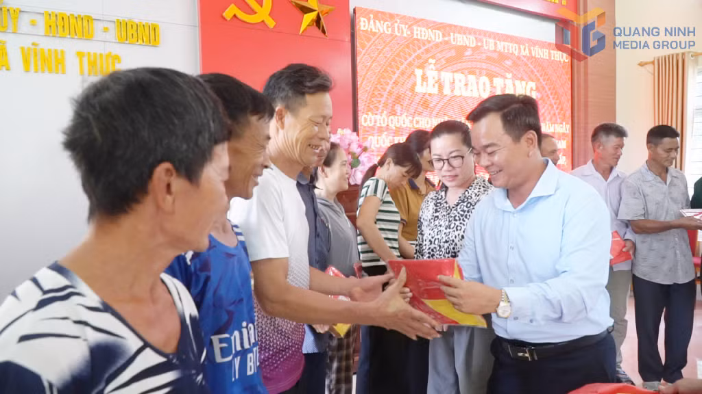 Lãnh đạo Xã Vĩnh Thực tặng cờ Tổ quốc cho ngư dân.