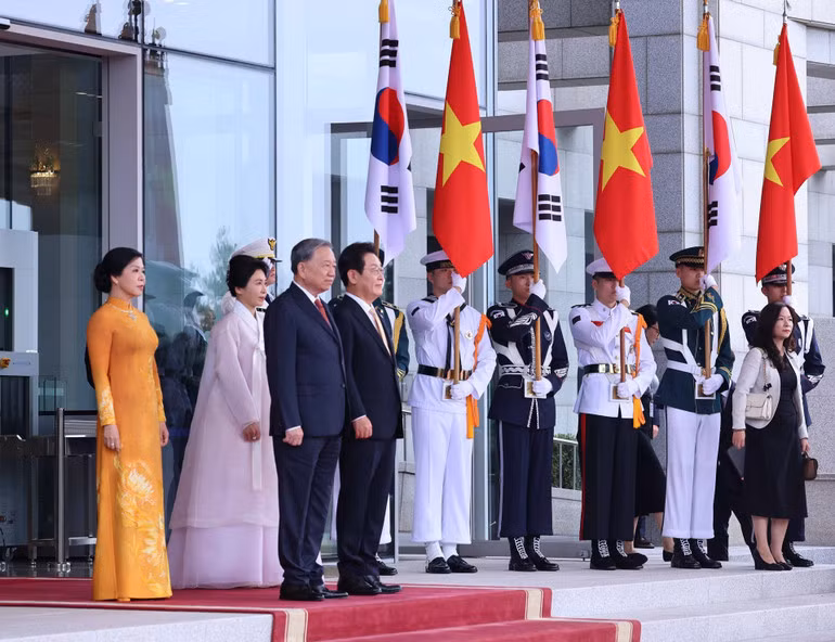 Tổng thống Hàn Quốc Lee Jae Myung và Phu nhân cùng Tổng Bí thư Tô Lâm và Phu nhân tại vị trí danh dự, nghe quân nhạc cử Quốc thiều hai nước. Ảnh: Thống Nhất - TTXVN